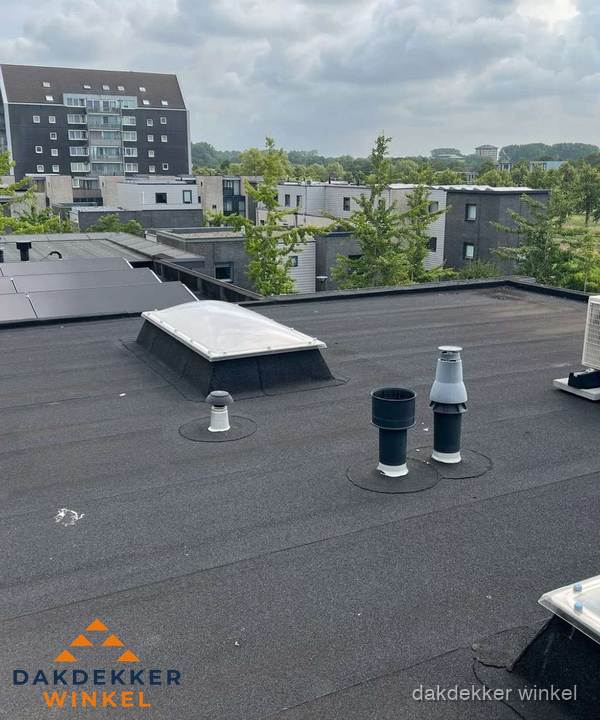 Groot plat dak met lichtkoepel en dakdoorvoeren in Winkel Groot plat dak met lichtkoepel en dakdoorvoeren in Winkel