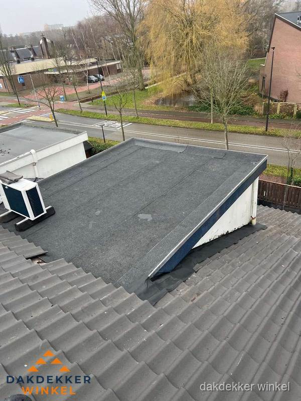 Plat dak met bitumen dakbedekking naast schuin pannendak in Winkel