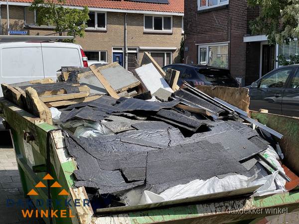 Afvalcontainer met gesloopt dakmateriaal tijdens dakkapel renovatie in Winkel Afvalcontainer met gesloopt dakmateriaal tijdens dakkapel renovatie in Winkel