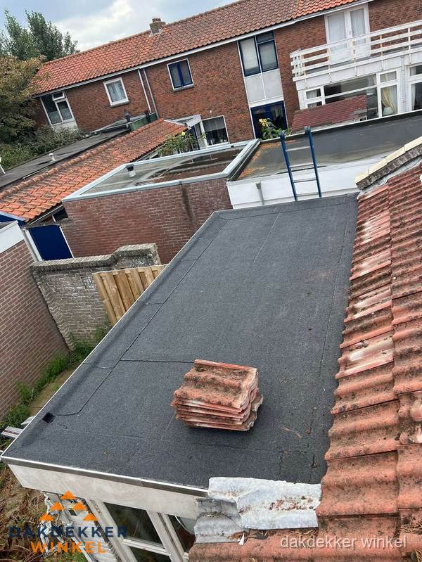 Aanbouw plat dak met reservepannen voor dakpannen vervangen in Winkel Aanbouw plat dak met reservepannen voor dakpannen vervangen in Winkel