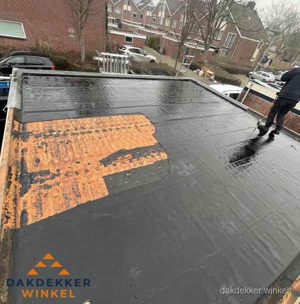 Dakdekker brengt EPDM dakbedekking aan op plat dak in Winkel Dakdekker brengt EPDM dakbedekking aan op plat dak in Winkel