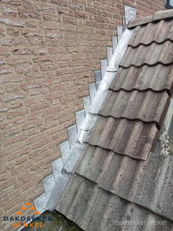 Loodslabben langs dakaansluiting bij bakstenen muur in Winkel