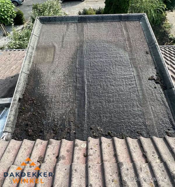 Verouderd plat dak met bitumen en slijtage voor lekkage inspectie in Winkel Verouderd plat dak met bitumen en slijtage voor lekkage inspectie in Winkel
