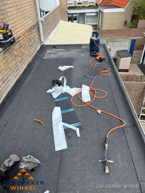 Dakdekkers bezig met bitumen dakbedekking in Winkel Dakdekkers bezig met bitumen dakbedekking in Winkel