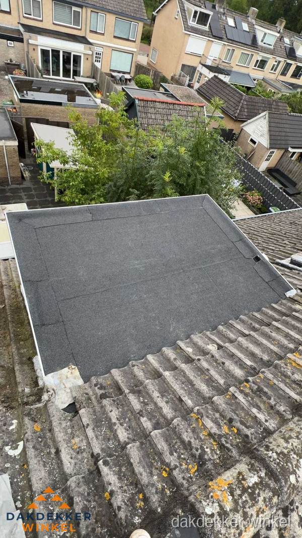 Plat dak aanbouw met bitumen dakbedekking in woonwijk Winkel