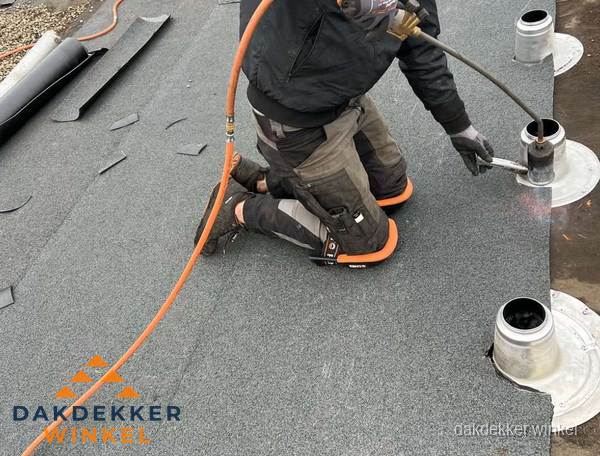 Dakdekker repareert bitumen dakleer bij dakdoorvoer in Winkel
