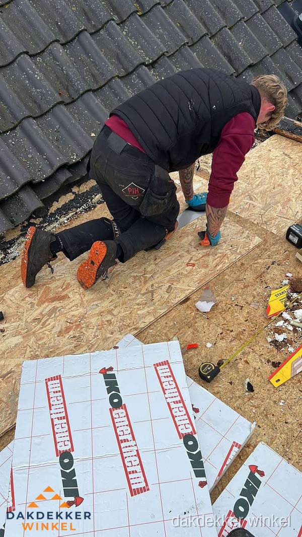 Dakdekker plaatst PIR-isolatieplaten op plat dak in Winkel