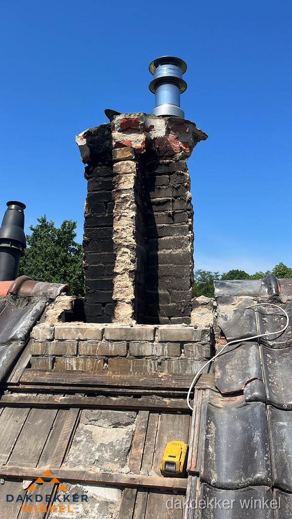 Beschadigde schoorsteen met nieuwe rookgasafvoer op oud dak in Winkel
