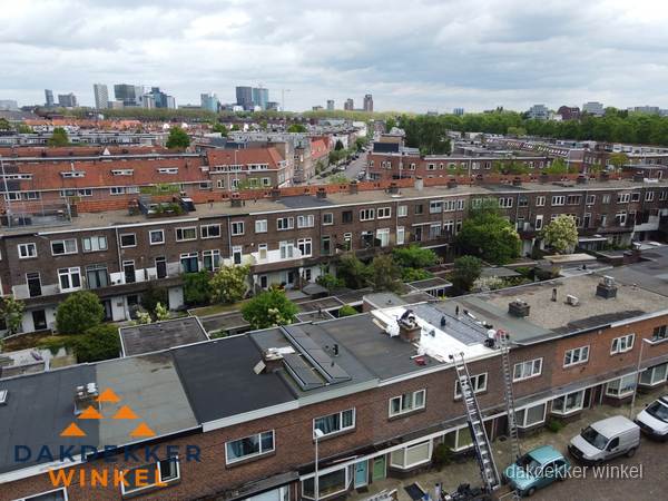 Spoed dakdekker aan het werk op plat dak in woonwijk Winkel